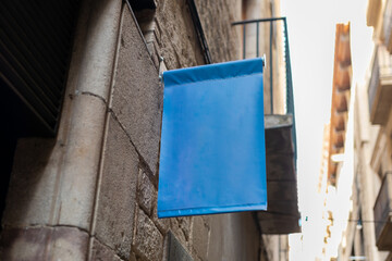 Blank sign mockup in the urban environment. Blue rectangle sign with blank space for cafe or restaurant name and logo, in an old town.