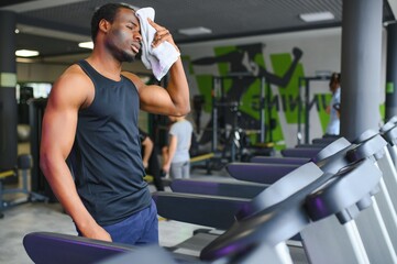 Thoughtful young man with towel in health club