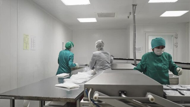 Factory Workers Use Vacuum Packaging Machine At Pharmaceutical Plant. Manual packaging At Production Factory. Manual Packaging Of Drugs. Labor Of Operators. Medicine Packaging Process. Manual Labor.