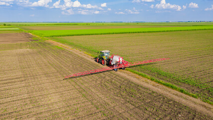 Aerial view on tractor as spraying field with sprayer, herbicide and pesticide © Roman_23203