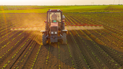 Aerial view on tractor as spraying field with sprayer, herbicide and pesticide