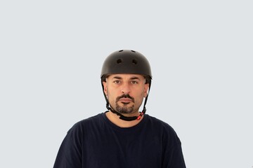 Portrait of a man wearing a black helmet and a dark blue shirt on a white background