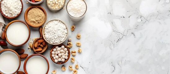 Vegan non dairy plant based milk in cupes and ingredients on light background. Lactose free milk substitute. Top view. Copy space image. Place for adding text or design