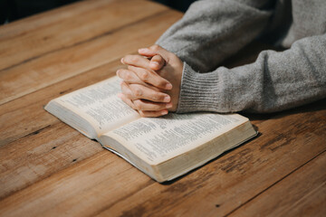 Woman sitting and studying the scriptures.The  wooden cross in the hands. Christian education concepts