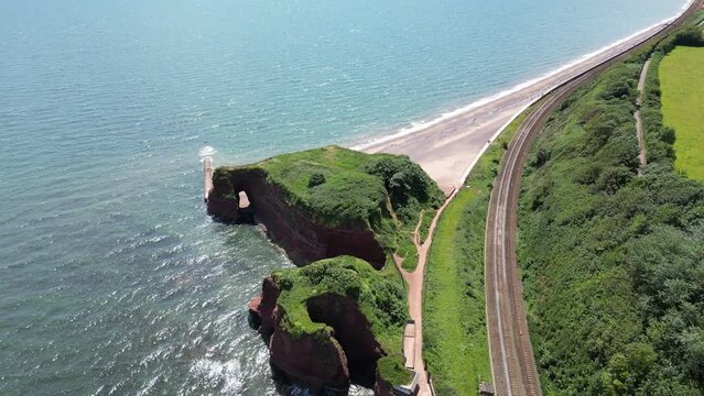 Dawlish Warren, River Exe, South Devon, England: DRONE VIEWS: Langstone Rock, the mainline railway track, the sea and a sandy beach. South Devon is a popular English holiday destination.