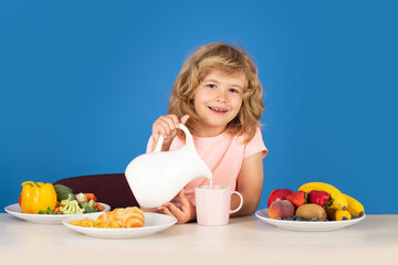 Happy smiling child pouring milk, studio isolated portrait. Kid with dairy milk.