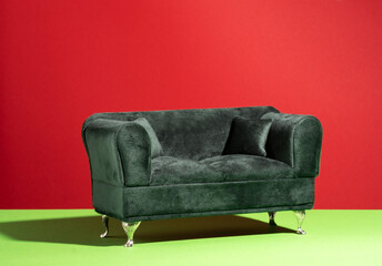 Green couch on green and red background.