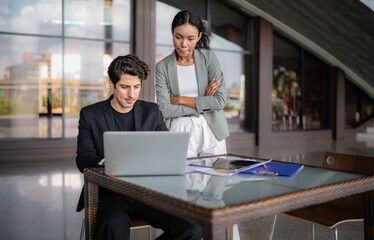 Latino man and African American businessperson brainstorming startup small business strategy together. Young multiracial businesswoman and colleague serious working on planning. Diversity people team.