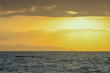 Waves coming into the shore and view of the coastline at sunset