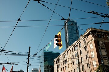 Fototapeta premium Urban scene of Robson Street in downtown Vancouver with traffic lights and overhead wires