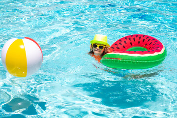 Summer swimming and relax, swim on ring in pool, poolside. Kid in swimming pool, relax swim on inflatable ring and has fun in water on summer vacation.