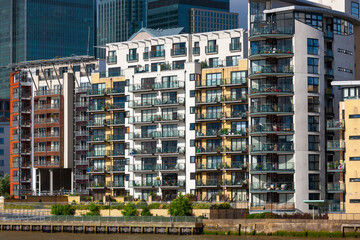 Luxury city living at River Thames waterfront, London, United Kingdom. Apartment balconies bathed in sunlight in the early evening.