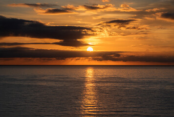 Sunset over the water with birds flying against sunlight on the Mediterranean Sea