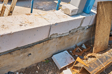 The first laying of concrete blocks on the foundation of the house. Construction site. Selective focus.