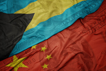 waving colorful flag of bahamas and national flag of china on the dollar money background. finance concept.