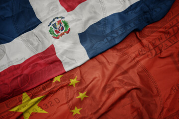 waving colorful flag of dominican republic and national flag of china on the dollar money...