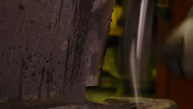 Worker Straightens Industrial Metal Detail By Hammer Tool. Using Hammer Tool To Correct Iron Detail Produced At Metalworking Factory. Manually Reshaping Metal Detail By Hammer Tool. Industry