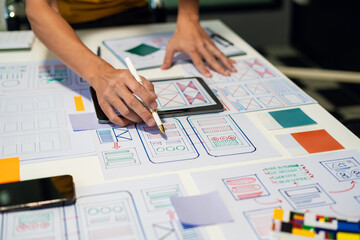UX developer and ui designer brainstorming about mobile app interface wireframe design with...