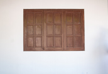 Brown wooden window and white house wall