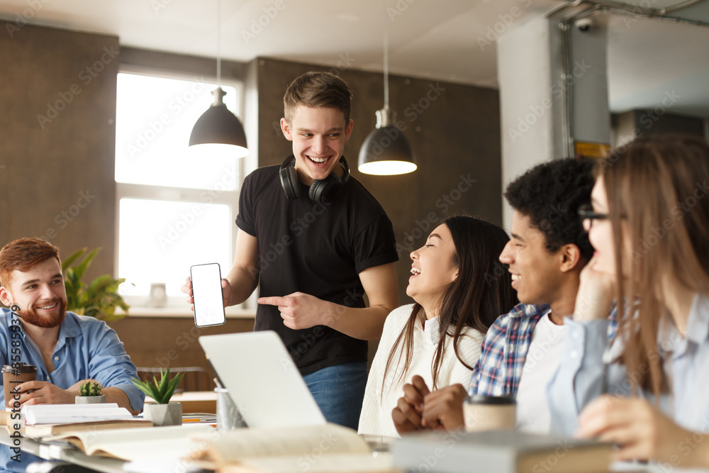 Poster a group of young adults is gathered around a table in a well-lit co-working space, engaging in a liv