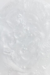 Fototapeta premium Macro shot of a moisturizer's texture showcasing its smooth, glossy surface with visible swirls and bubbles. This detailed close-up highlights the product's creamy and hydrating properties