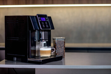 Modern coffee machine with glass cup of latte in kitchen