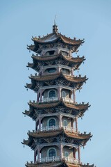 Close-up of a traditional Chinese pagoda with intricate details against a clear blue sky.