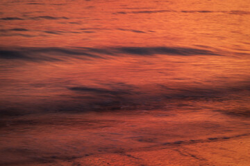 Ocean and small motion blurred waves at sunset. Natural tropical travel, vacation and summer background with copy space.