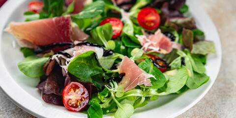 salad jamon green leaf lettuce, tomato appetizer meal food snack on the table copy space food background rustic top view 
