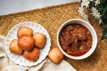 Fried Mantou served in white plate with Beef Rendang.  Fusion food.
