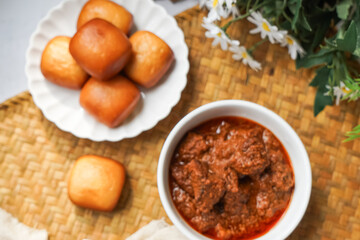 Fried Mantou served in white plate with Beef Rendang.  Fusion food.