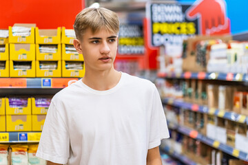 Supermarket shopper examines merchandise on shelves in Dubai.