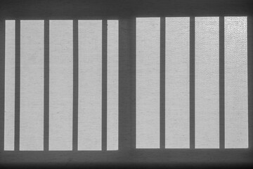 Background of window roller blind with bars' shadows, black and white