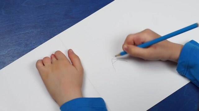Syndactyly of the fingers: child after the operation of separation works with his/her fingers and learns to write letters on a sheet of paper
