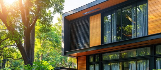 Beautiful exterior of modern luxury home with linear design and elegant use of wood and metal, surrounded by trees on bright sunny day. Copy space image. Place for adding text and design