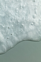 Fototapeta premium Macro shot of a moisturizer's texture showcasing its smooth, glossy surface with visible swirls and bubbles. This detailed close-up highlights the product's creamy and hydrating properties