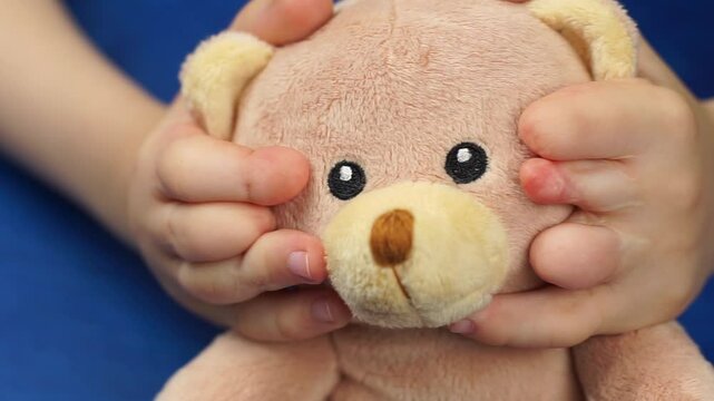 Close up shot of hands with syndactyly and soft toy. Acceptance of children with special needs.
