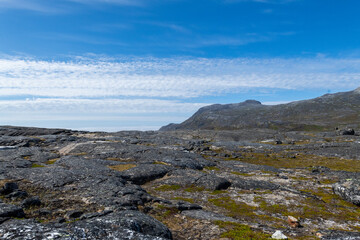Greenland Nanortalik lava stones volcanic mountain fjord arctic landscape on a sunny day