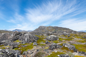 Greenland Nanortalik arctic lava stones volcanic mountain landscape on a sunny day with feather clouds