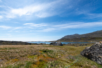 Greenland Nanortalik arctic lava stones volcanic mountain landscape on a sunny day with feather clouds
