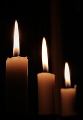 three candle flames in the dark