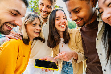 Young group of student friends watching social media content on cellphone. Millennial people...
