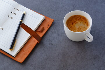 ミルクをたっぷり入れたコーヒー、カフェ・ラッテを飲みながら、日記をつけているイメージ
