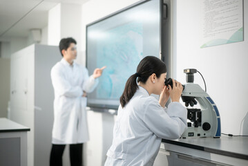 Naklejka premium doctor using microscope in lab