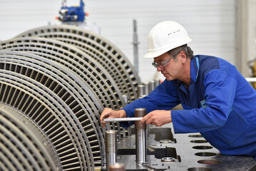 workers assembling and quality control of gas turbines in a modern industrial factory - checking...