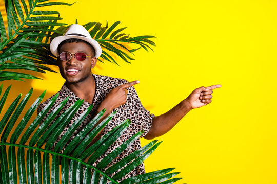 Photo of handsome man wear trendy leopard print clothes recommed empty space isolated on yellow color background