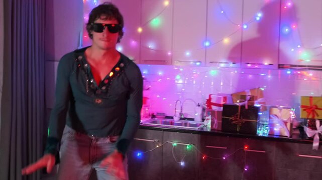 Dynamic movement of young man dances to beats at home party bash with neon lights vibe, celebrating birthday, weekend holiday background.