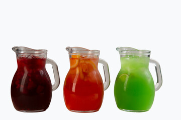Various lemonades in carafes. Isolated on white.