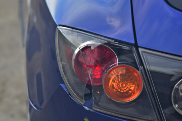 Closeup of Broken blue car tail light following a car accident and traffic accident on road at Thailand.
