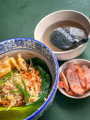 Noodle soup with wonton dumplings and vegetables. separate sauce. Top view